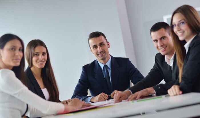 colegi la locul de munca aduncati in jurul mesei